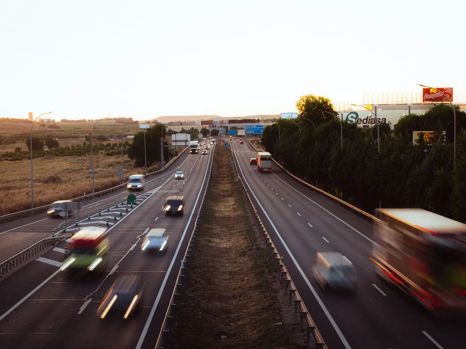 Autovía de varios carriles a las afueras de Madrid al atardecer