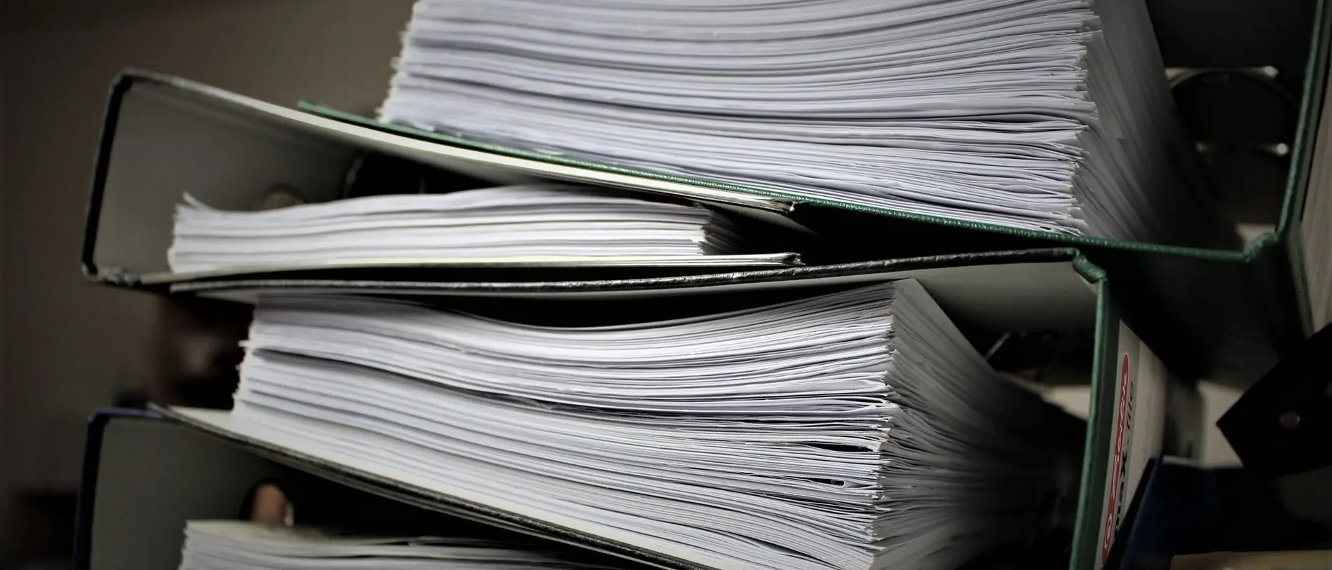 Carpetas de archivo apiladas y llenas de documentos